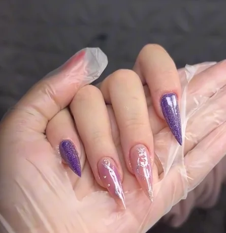 Unhas em roxo brilhante e rosa com detalhes cintilantes